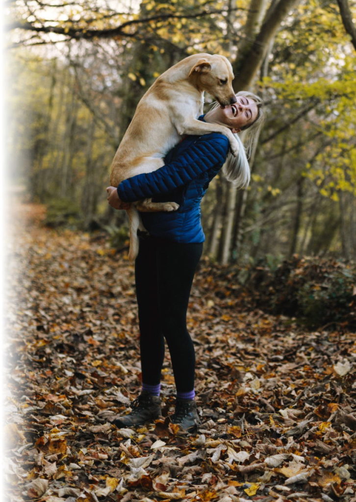 Woman Carrying Her Dog in the Woods